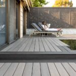 PVC Decking by TimberTech. Patio with two lawn chairs in the background. A woman sitting on the patio chair.